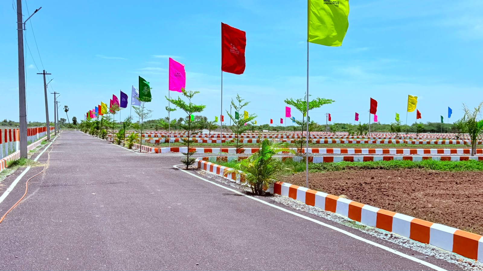 Internal blacktop road lined with colourful flags at Jay Enclave